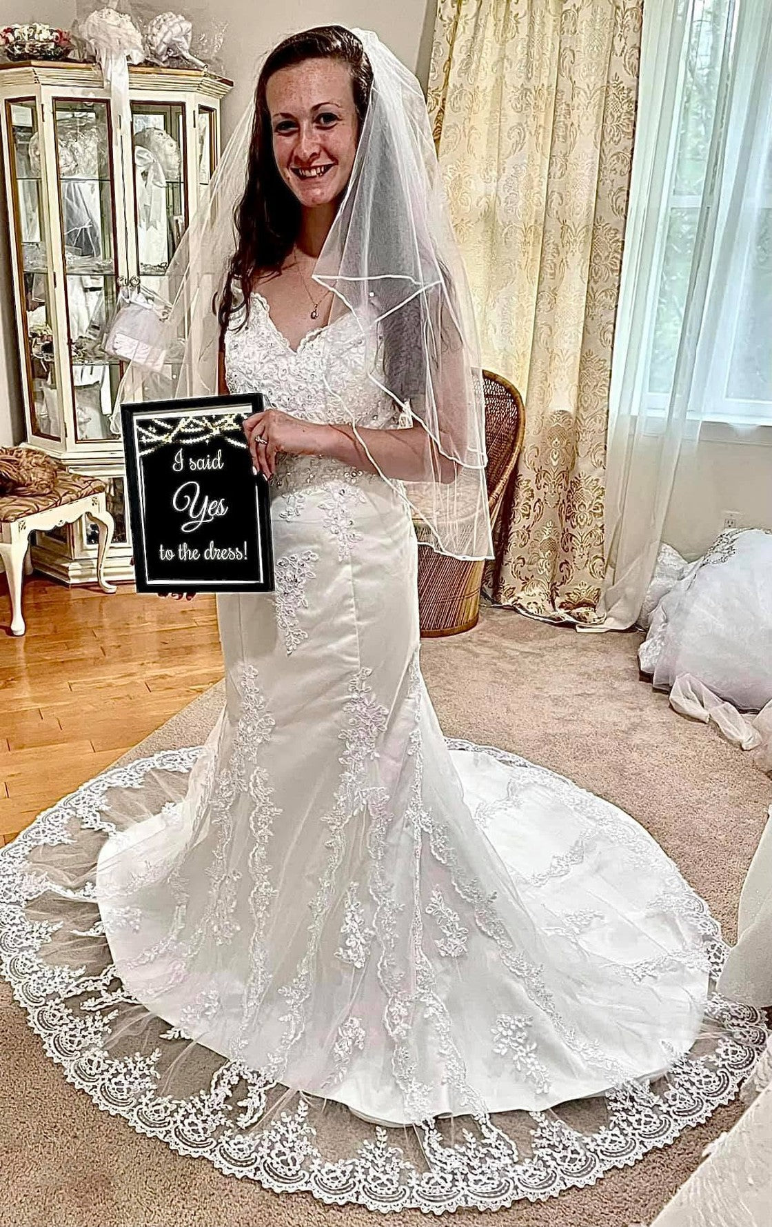 Real bride wearing a handmade Candy Bridal dress, holding her 'I said Yes to the dress' sign